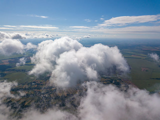 High flight in the clouds over agricultural fields.