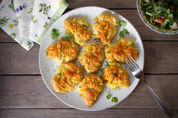 Smashed new baby potatoes with garlic butter and cheese on wooden background close up. Clean eating. Flat lay, overhead