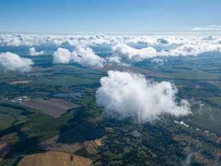 High flight in the clouds over agricultural fields.
