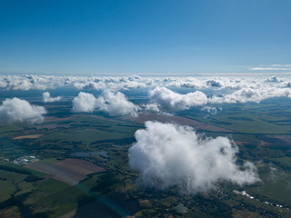 High flight in the clouds over agricultural fields.