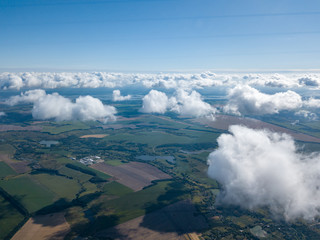 High flight in the clouds over agricultural fields.