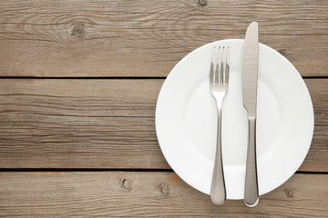 Table setting with white plates, and cutlery - fork and knife. Shot from above.