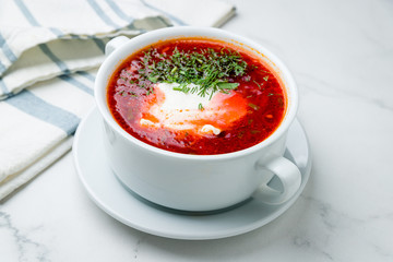 Borscht with sour cream on marble table