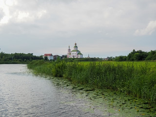 photo of the wide Suzdal river near Russian white stone Orthodox churches