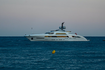 Cagnes-sur-mer, France 22.07.2020 Modern luxury yacht on the sea and flying passenger plane later evening