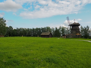 photo of a large field next to a river above a cloudy sky