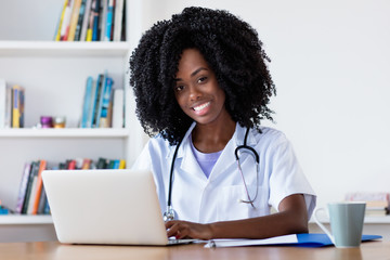 Laughing african american nurse or medical student at computer