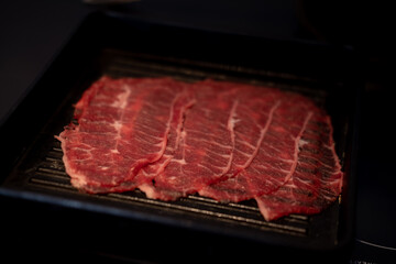 Fresh raw pork beef slice for grill serving on black tray