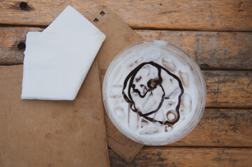 Top view of plastic cup of iced fresh milk with chocolate sauce