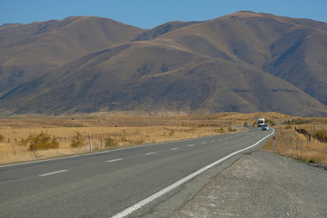 Fototapeta premium Straight road leading towards a snow capped mountain in New Zealand
