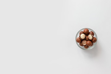 Macadamia nuts in glass bowl on gray background design for poster, article or banner