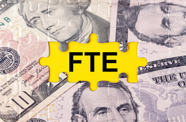 Fototapeta premium Puzzle with the image of dollars in the center of the inscription -FTE