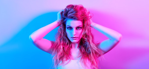 Fototapeta na wymiar Fashion. Woman in colorful neon light, make-up. Beautiful sexy girl, stylish wet hair, trendy makeup. Party disco neon style. Creative art beauty portrait, fashionable model face, make up
