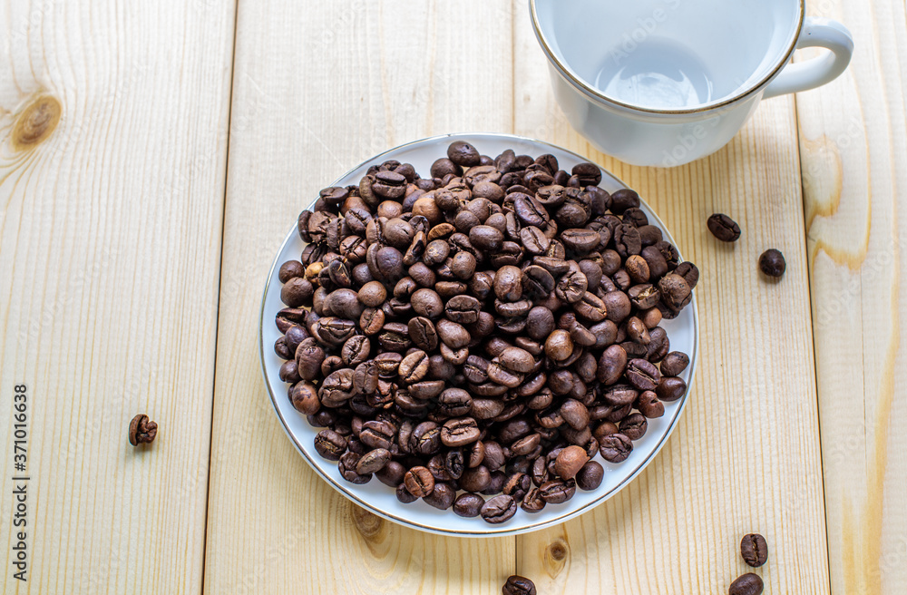 Poster white mug with cup of coffee beans on wooden background with selective focus and crop fragment