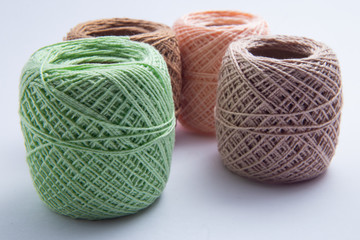 Quatro novelos de linha com cores variadas.