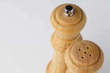 Wooden mills with salt and pepper on white