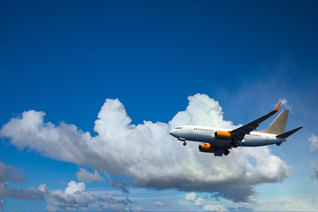 Fototapeta na wymiar Airplane in the clouds is ready for landing at the airport