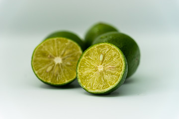 whole and half with slice of fresh green lime isolated on white background. Fresh and real tropical fruit.