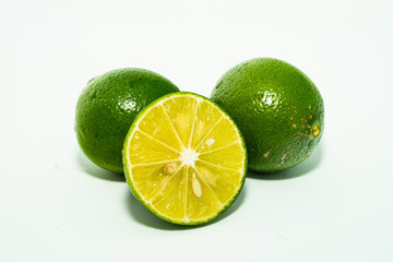 whole and half with slice of fresh green lime isolated on white background. Fresh and real tropical fruit.
