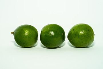 whole and half with slice of fresh green lime isolated on white background. Fresh and real tropical fruit.