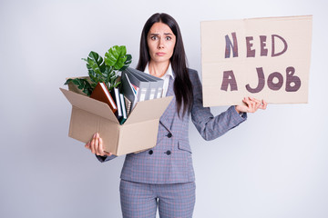 Photo of unhappy worker young dismissed lady financial crisis lost work hold carton box stuff fired quit hold placard banner search new opportunity formalwear isolated grey color background