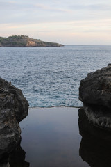 Sunset at the Angel's Billabong is natural infinity pool on Nusa Penida Island, Bali, Indonesia. Amazing  view with rocky mountains and with clear water of Indian Ocean 