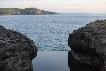 Sunset at the Angel's Billabong is natural infinity pool on Nusa Penida Island, Bali, Indonesia. Amazing  view with rocky mountains and with clear water of Indian Ocean 
