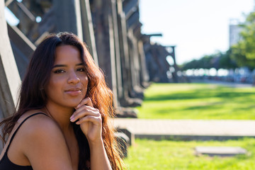 Obraz premium young woman sitting or standing next to a wooden and iron bridge