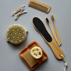 Bamboo toothbrushes, natural soap and bath loofah on a wooden plate, wooden dry massage brush and...