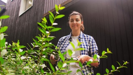 gardening and people concept - happy senior woman with pruner or pruning shears cutting branches at summer garden - Powered by Adobe