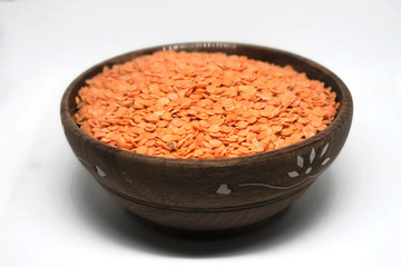 Red Lentils in a wooden bowl on white background