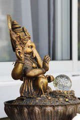 Golden ganesha statue on the stone altar.