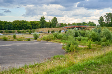 Fototapeta na wymiar Rural landscape with a highway and bridge. Huge unused asphalt parking lot. 