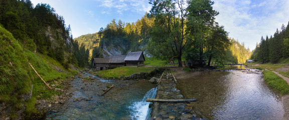 A historic grist mill building on the banks of Creek in Carpathian mountains, Slovakia, Europe. Old mill powered by water by using wooden water wheel. Sunn day in summer season.Romantic place. © Michal