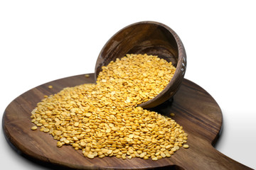 Dry Split Yellow Lentils in a wooden bowl on wooden board