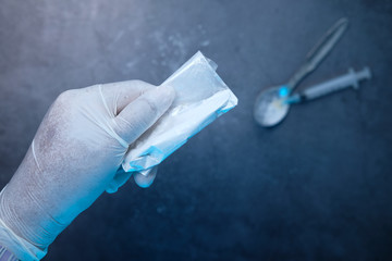 drug addiction concept with hand holding heroine packet on black backgrund 