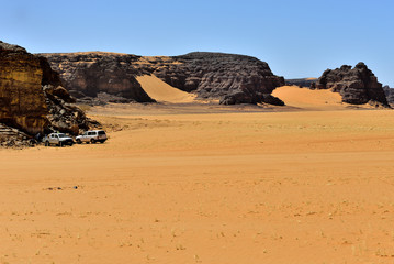 Fototapeta na wymiar SAFARI IN THE SAHARA DESERT IN ALGERIA. NATIONAL PARK OF TADRART. SAND DUNES AND ROCK FORMATIONS. 