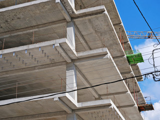 Closeup of a reinforce concrete frame structure of a new multi-story apartment building in construction showing slabs, beams and columns