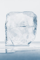 Transparent ice block, with reflection, isolated on white background.
