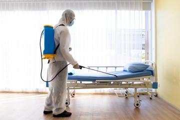 Staff protective suit PPE and mask.Cleaning and Disinfection in a room of hospital amid the...