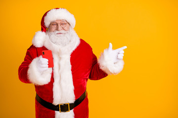 Fototapeta na wymiar Photo of jolly holly fat santa claus use smartphone point finger copyspace follow x-mas christmas eve adverts discount wear cap headwear isolated bright shine color background