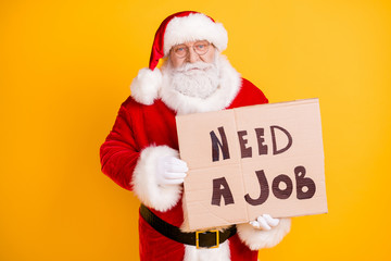 Portrait of his he nice frustrated white-haired Santa holding in hands paper card promo looking job industry crisis change occupation isolated bright vivid shine vibrant yellow color background