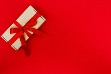 Gift box decorated with ribbon isolated on red background. Christmas and New Years concept. Copy space.