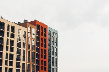 Fragment of modern residental building exterior in the daylight - against grey sky as background...