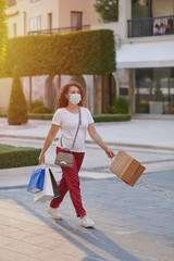 A young woman in a mask going shopping in the city