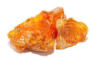 Transparent natural piece of amber on a white background. Copal. Fossil ancient resin from tropical trees. Sun stone. Mineral. Material for jewelry. Colored crystal. Inclusions in amber