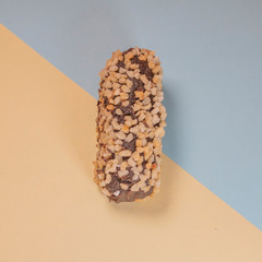 Chocolate dessert with nuts on a yellow-blue background close-up.