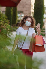 Shot of a gorgeous and elegant young woman in mask out on a shopping spree