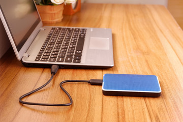 Portable external hard drive USB3.0 connect to laptop computer on desk, Data transfer or backup...