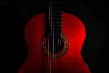 spanish classical red guitar close-up on a black background